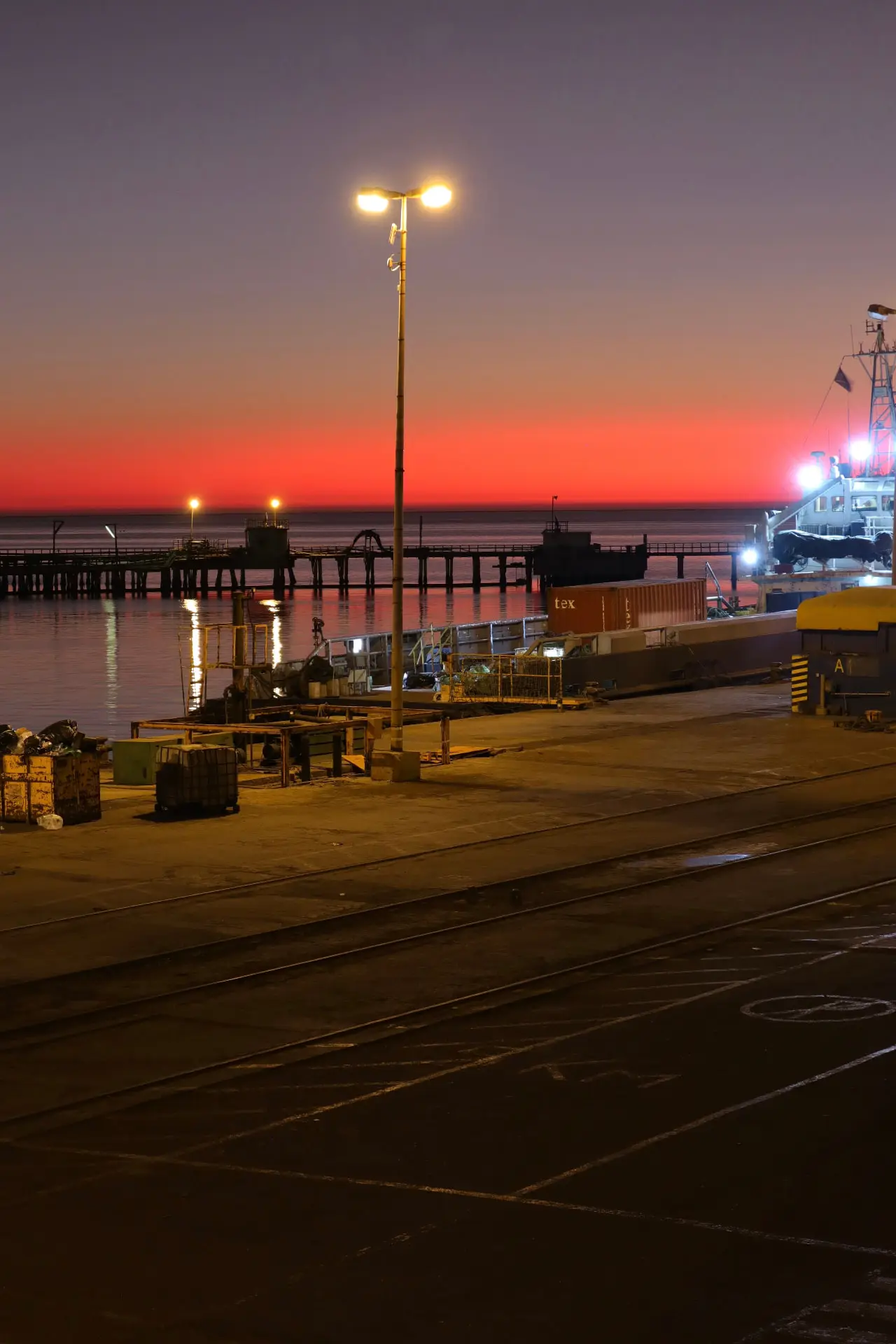 Port Hedland wharf lit at sunset with freight equipment on the apron